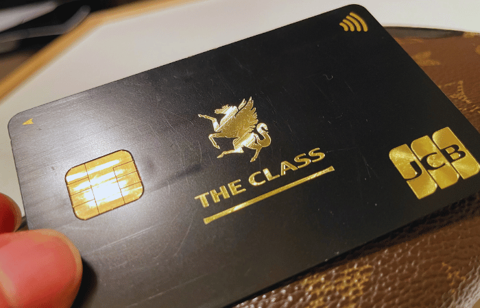 JCBザ・クラスのブラックカードを手に持っている様子。黒地に金色のペガサスロゴが入った高級感あるクレジットカード。